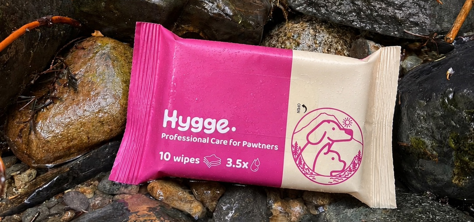 Hygge paw care wipes package on wet rocks outdoors for cleaning and caring for paws